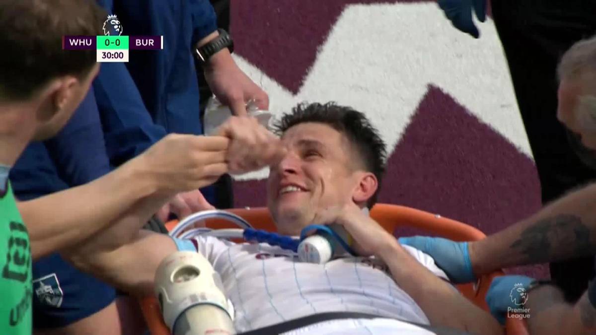 Ashley Westwood saliendo del London Stadium en camilla tras sufrir la grave lesión y lo hizo con esta sonrisa que asoma entre las lágrimas al recibir los ánimos de sus compañeros.