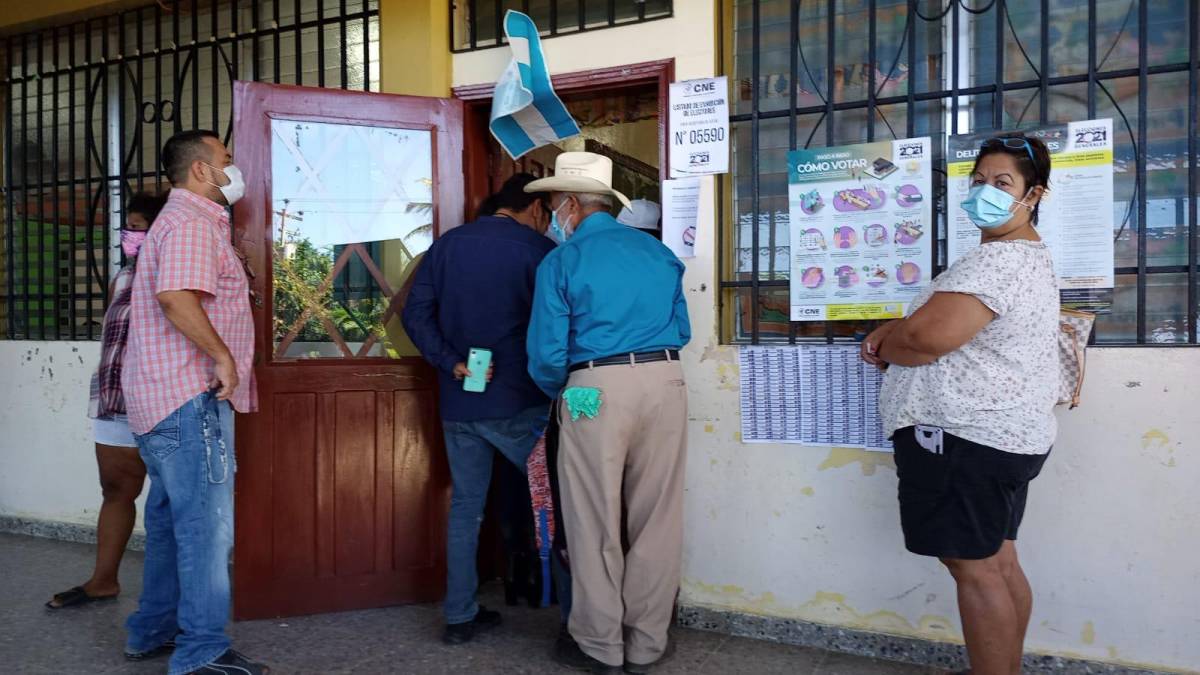 Hondureños hacen fila en el centro de votación de la escuela Marco Aurelio Soto.
