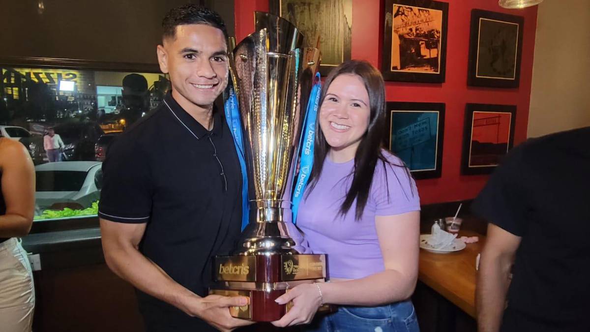 El volante Carlos Pineda junto a su novia y la Copa conquistada por el Olimpia.