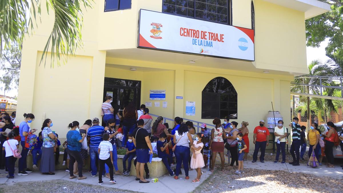 Menores acompañados de sus padres acuden al centro de triaje de La Lima, Cortés.