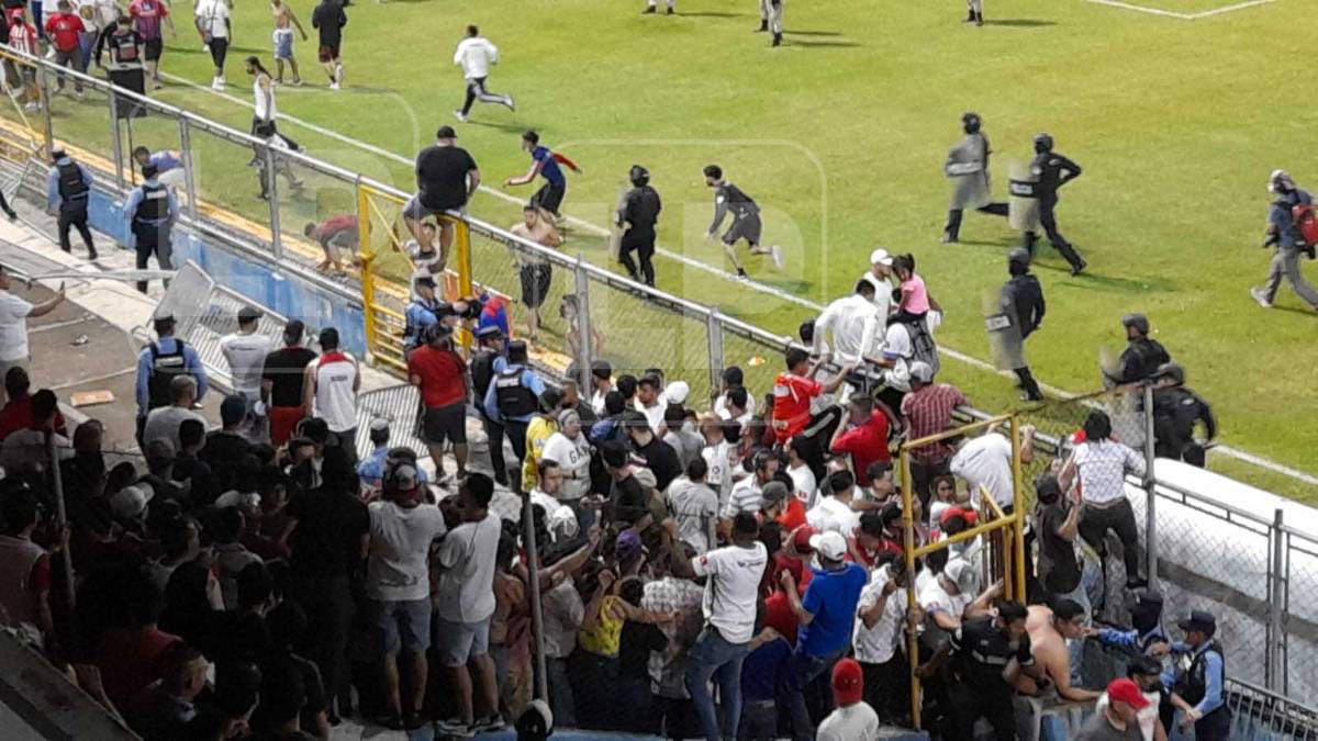 Momento de la invasión de aficionados que se dio al medio tiempo en el clásico Olimpia vs Motagua.