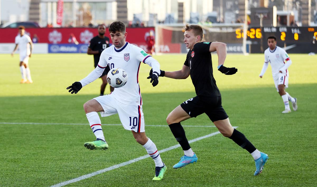 El canadiense Alistair Johnston marcando a Christian Pulisic.