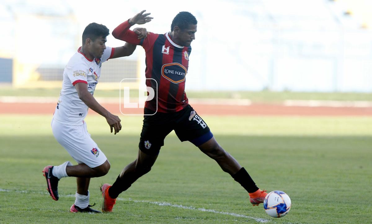 Carlo Costly conduciendo el balón ante la marca de un jugador del Villanueva FC.