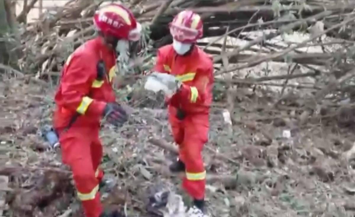Equipos de rescate buscando en el lugar donde un avión de pasajeros de China Eastern se estrelló contra la ladera de una montaña en el condado de Tengxian en la ciudad de Wuzhou.