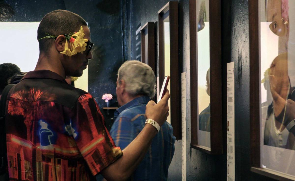 Un homnre toma fotos durante la exposición ¨Masculinidades¨.