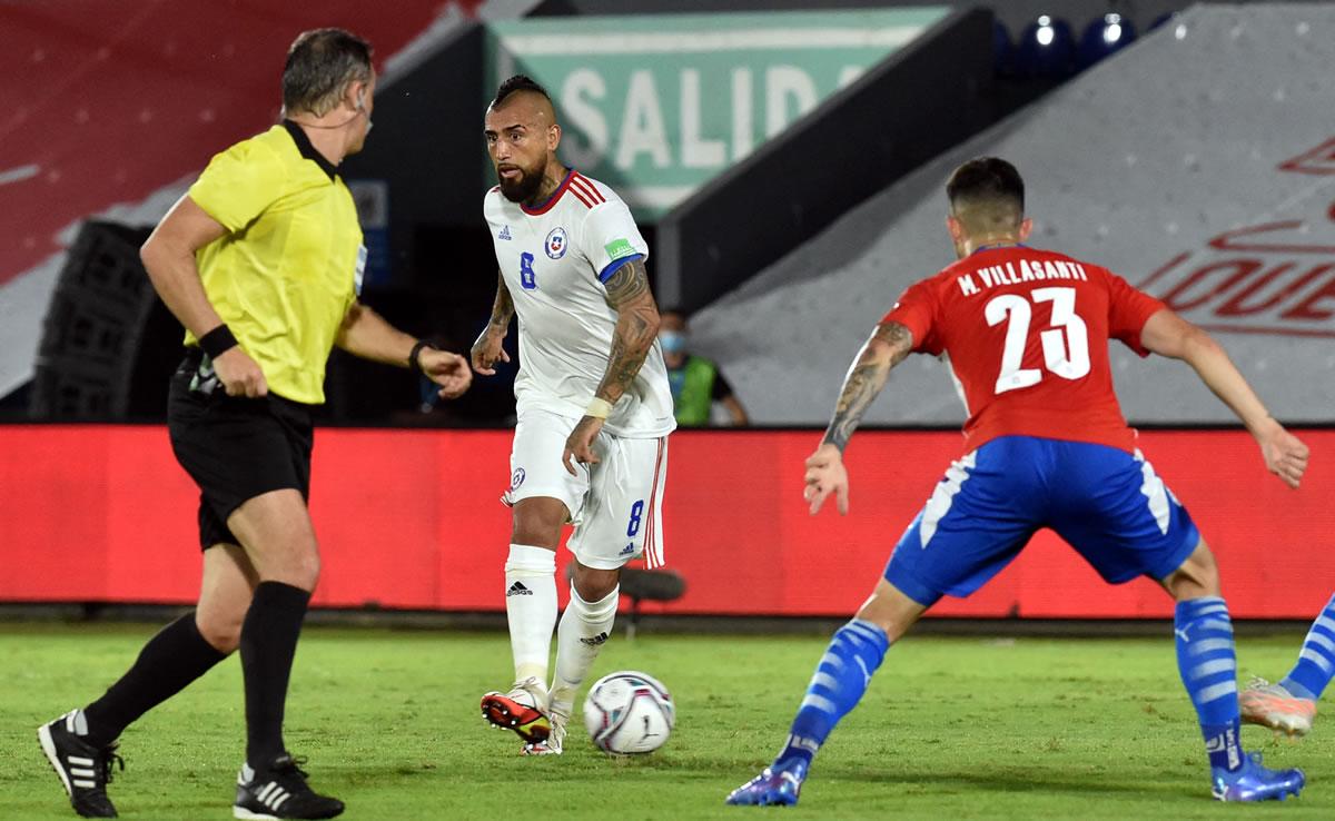 Arturo Vidal dando un pase ante la marca del paraguayo Mathias Villasanti.