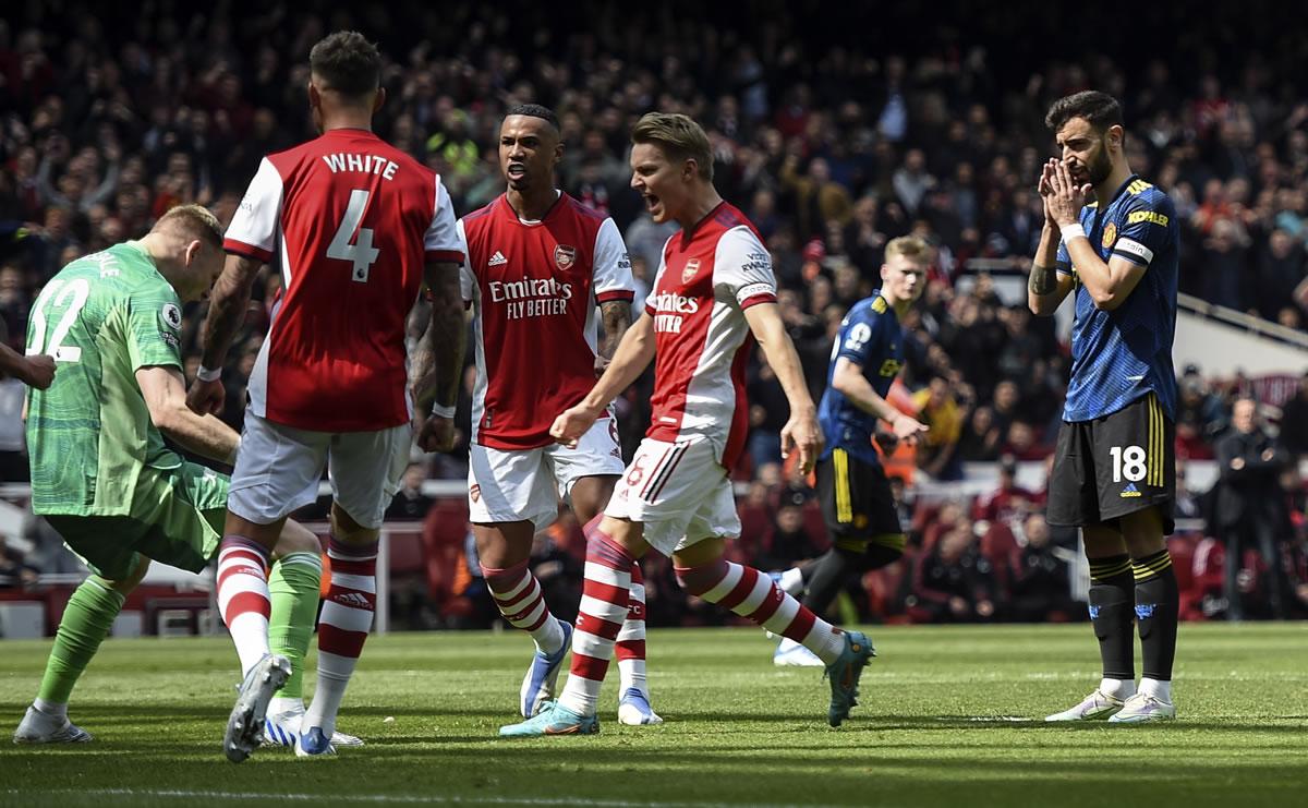 Bruno Fernandes se lamenta tras el penal que falló, mientras los jugadores del Arsenal celebran con el portero Aaron Ramsdale.