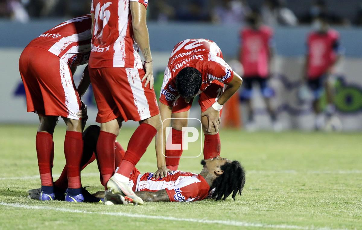 Henry Figueroa es auxiliado por sus compañeros tras caer lesionado.
