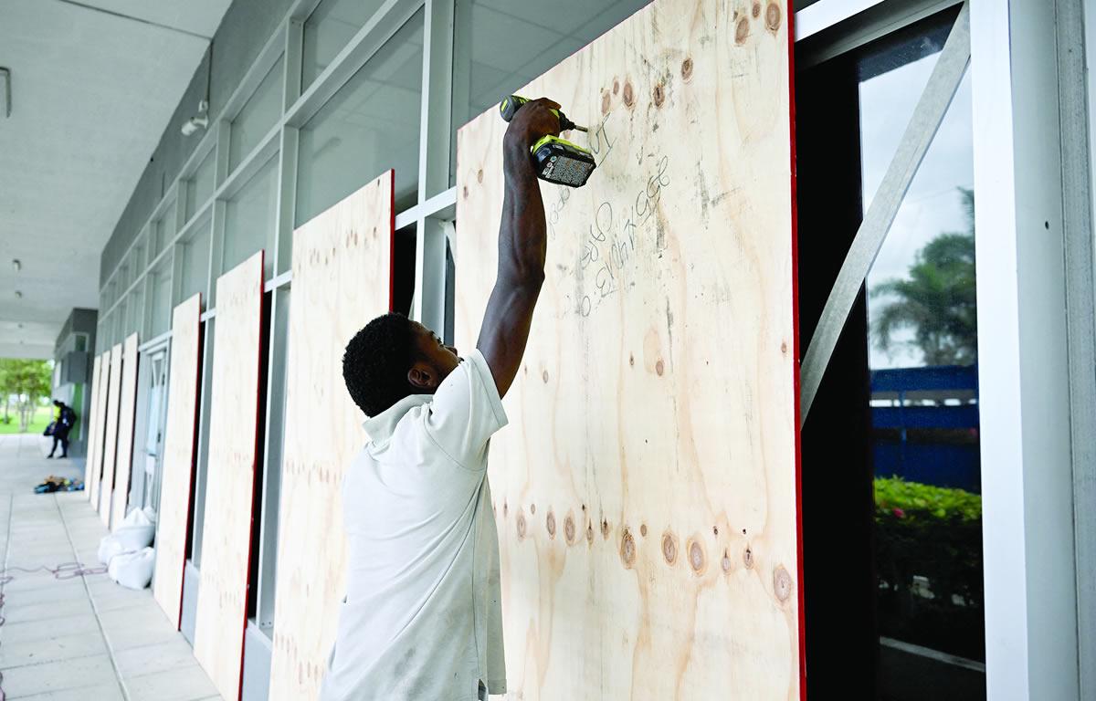 $!Las personas en la isla caribeña protegían con paneles de madera sus propiedades.
