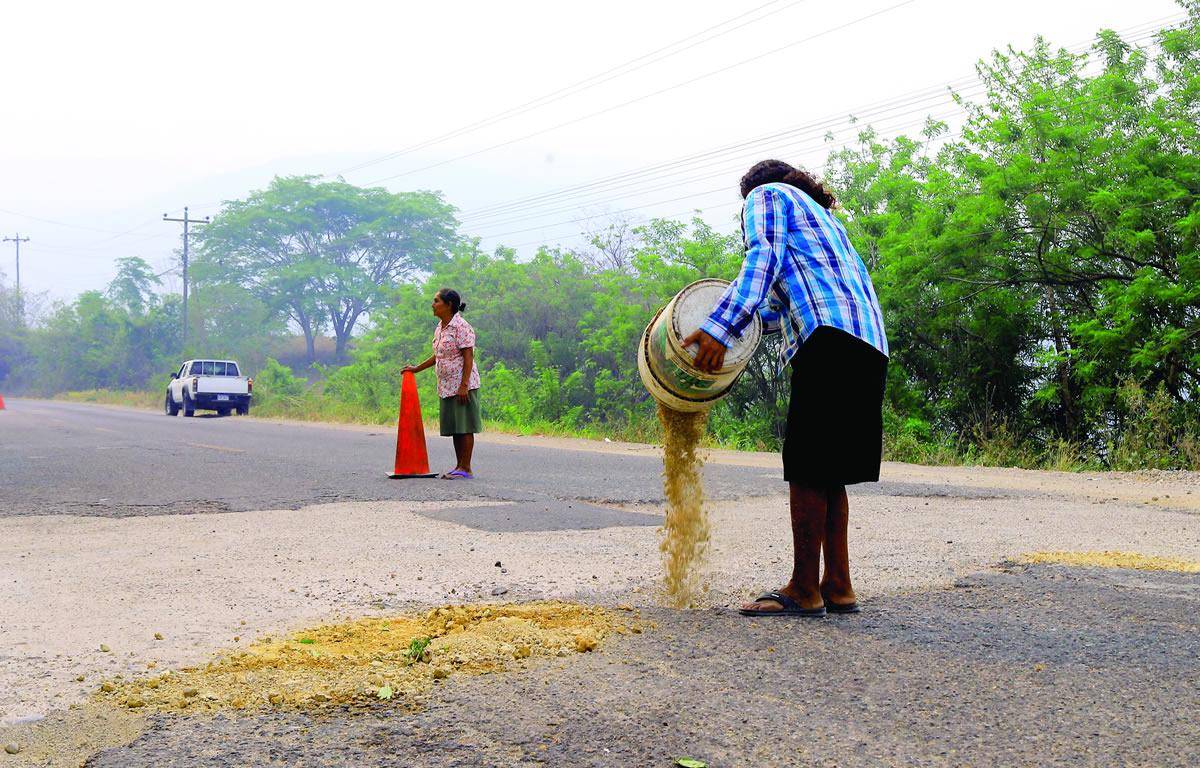 $!Toda la población de la carretera dio su aporte para contribuir al trabajo de eliminar baches.