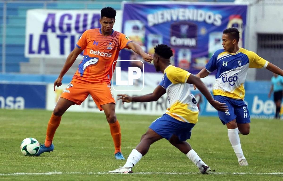 Jack Jean-Baptiste cuidando el balón ante la marca de dos jugadores del Honduras Progreso.