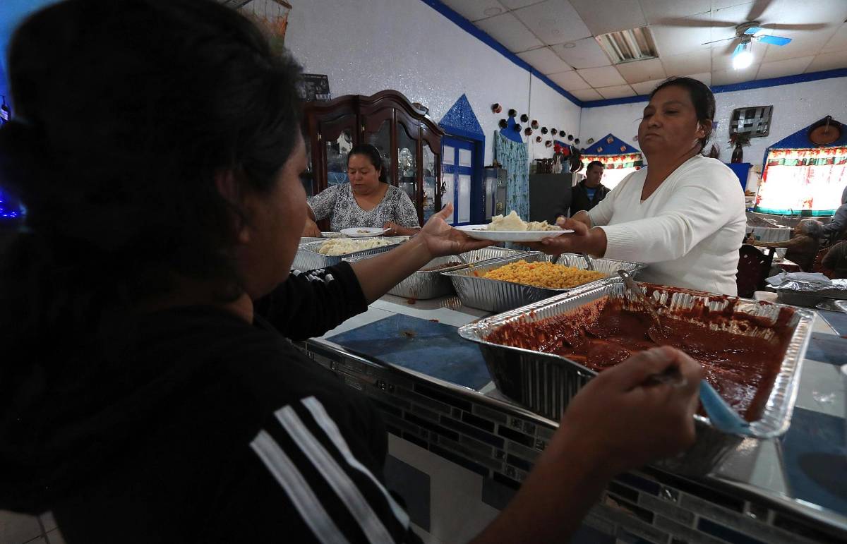 Migrantes reciben alimentos en el albergue 'Pan de Vida' con motivo del 'Día de Acción de Gracias', el jueves en Ciudad Juárez.
