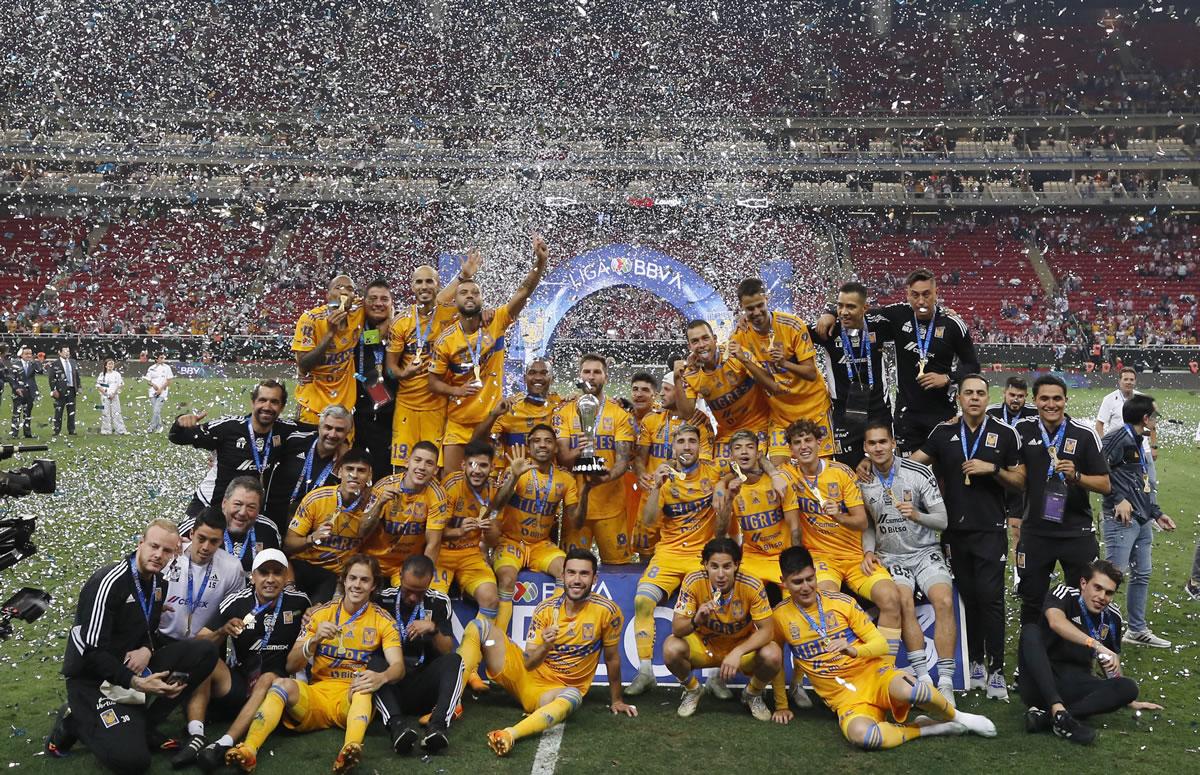 Los jugadores de Tigres celebrando con el trofeo de campeones.