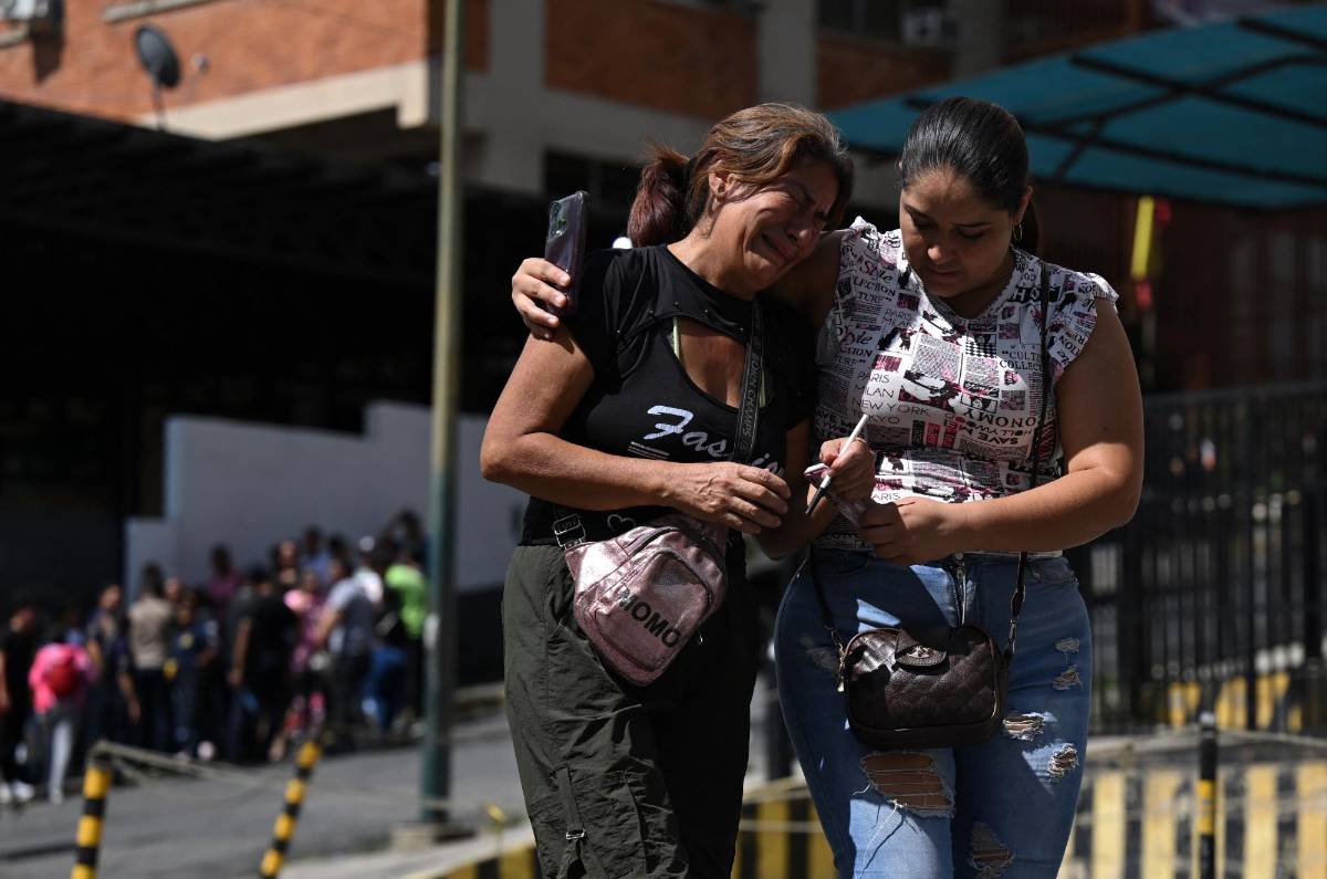 Familiares de manifestantes detenidos esperan noticias de sus seres queridos frente a una estación de policía en Caracas.