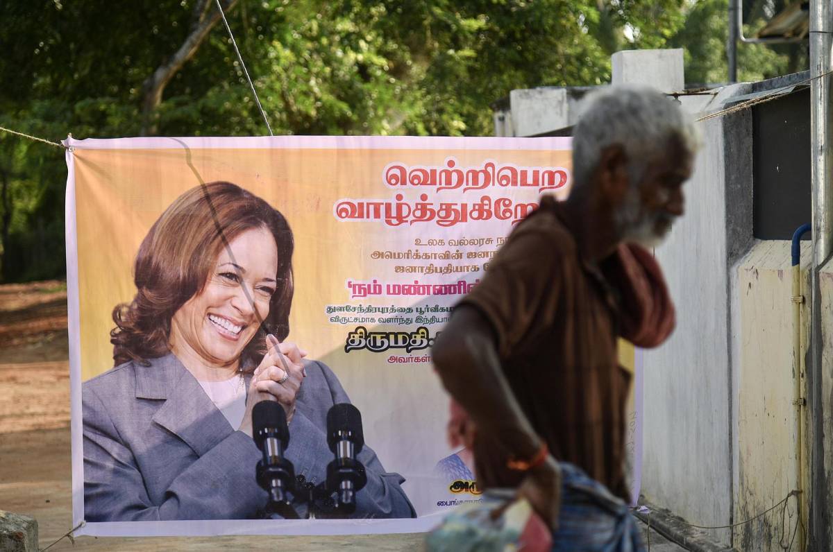 Un hombre indio pasa junto a un cartel que muestra a la vicepresidenta de EE. UU. y candidata presidencial demócrata Kamala Harris, exhibido en su aldea ancestral de Thulasendrapuram, en el estado de Tamil Nadu, India, 05 de noviembre de 2024.