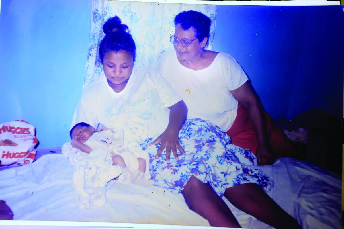 Doña Esperanza junto a una joven y su bebé, poco después del parto asistido por ella.