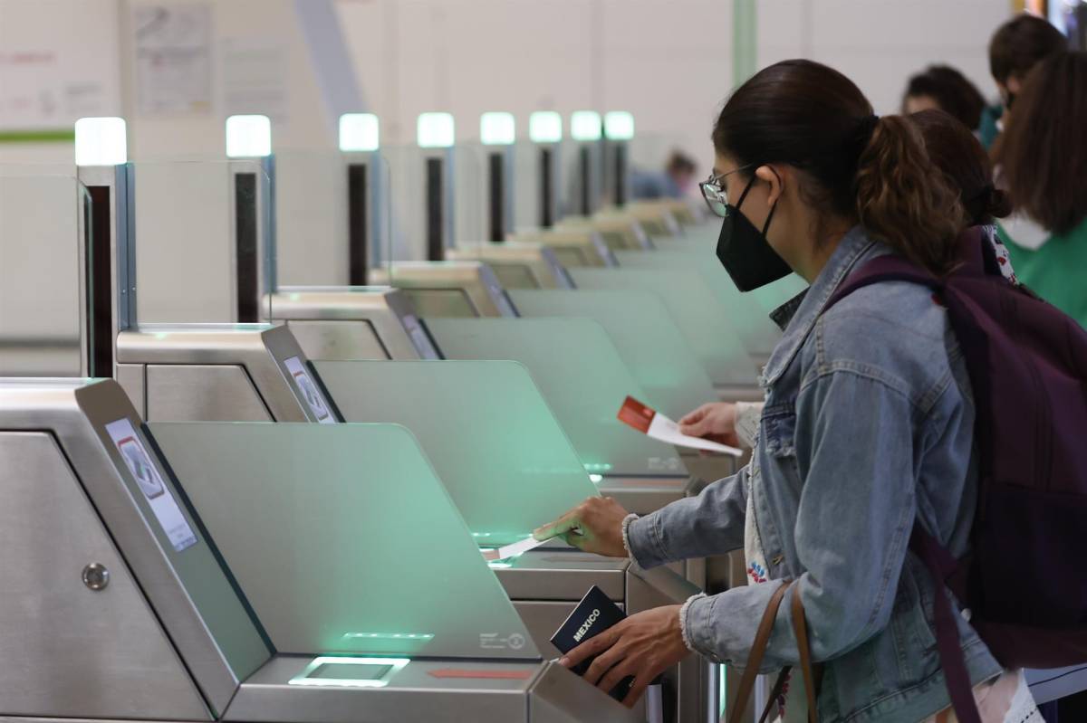 Viajeros escanean sus billetes con código QR en los controles de acceso de un aeropuerto.