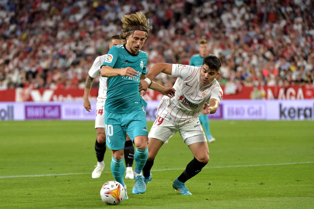 El croata Luka Modric protege la pelota del argentino Marcos Acuña.