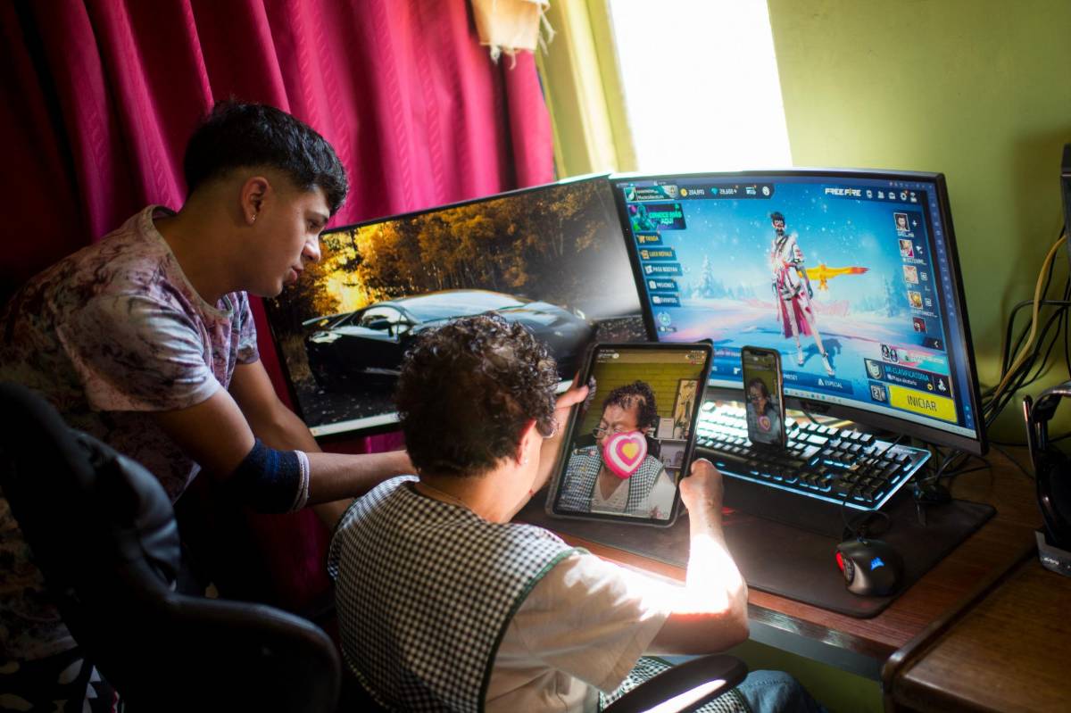 María Elena Arévalo, de 81 años, conversa con sus seguidores de las redes sociales Tik Tok, acompañada de su nieto Héctor Carrasco.