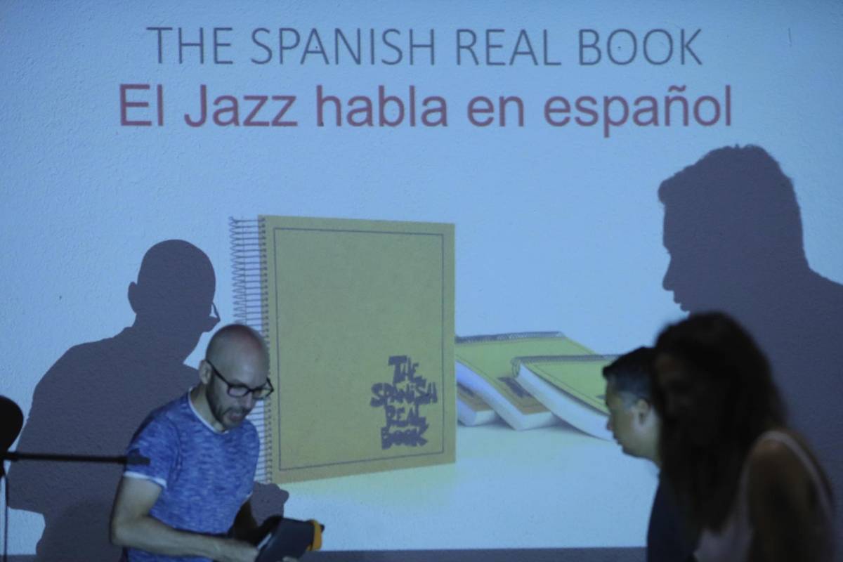 Fotografía de la proyección del libro “The Spanish Real Book” en un evento publico en el escenario el Auditorio de la Escuela Nacional de Música en Tegucigalpa.