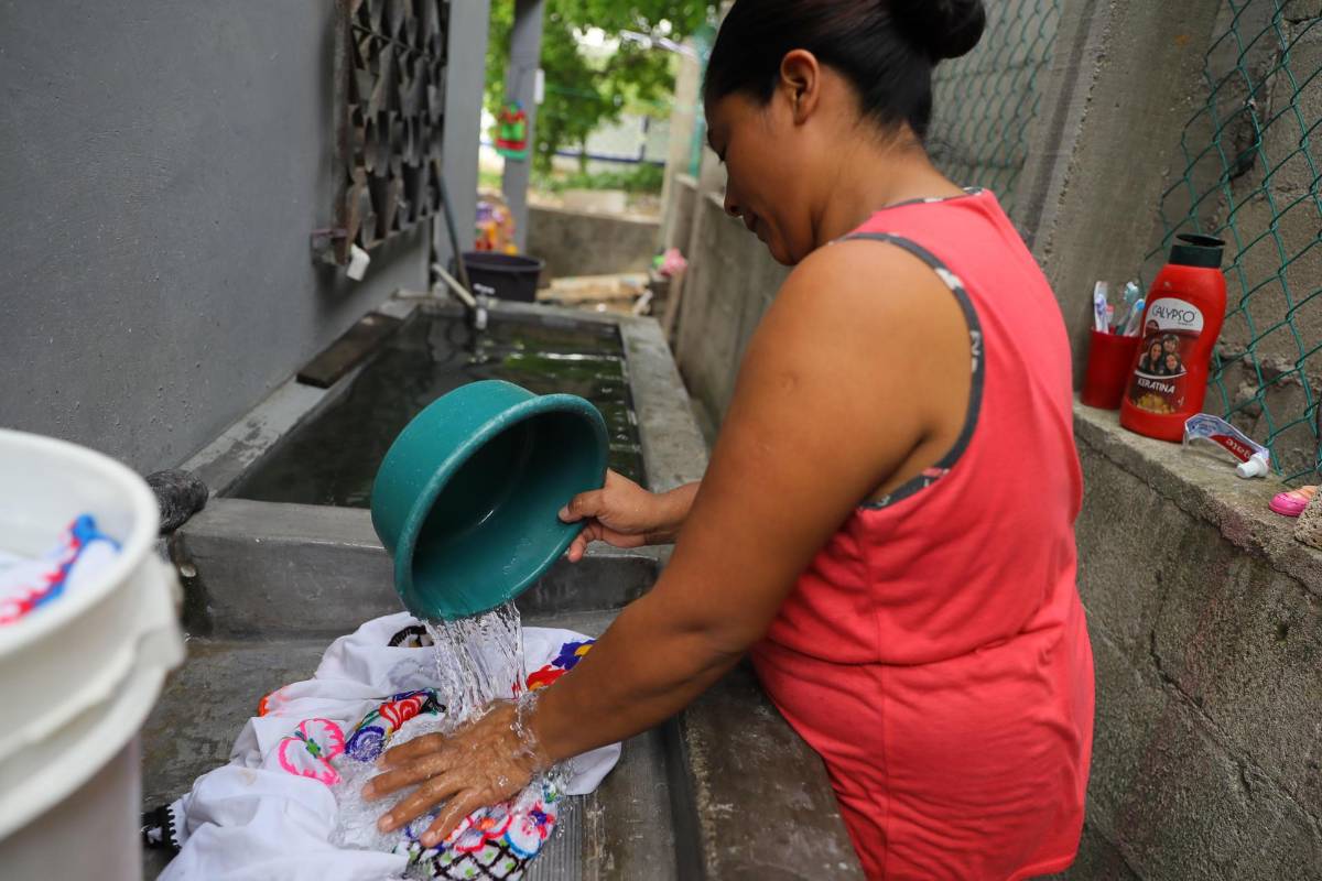 Una mujer lava ropa en un barrio del municipio de Choloma, beneficiado con proyectos comunitarios para el acceso a agua potable.