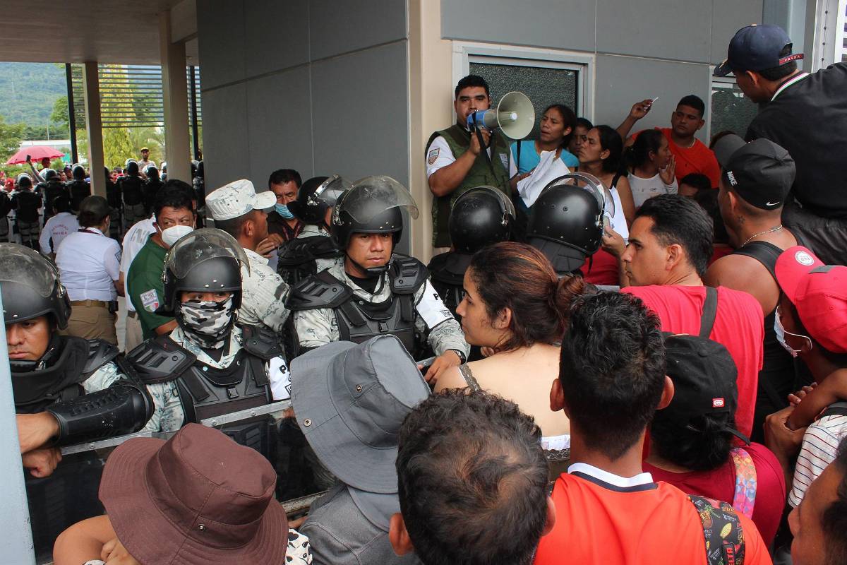 Migrantes se aglomeran frente a una oficina del INM en Tapachula para solicitar una visa humanitaria.