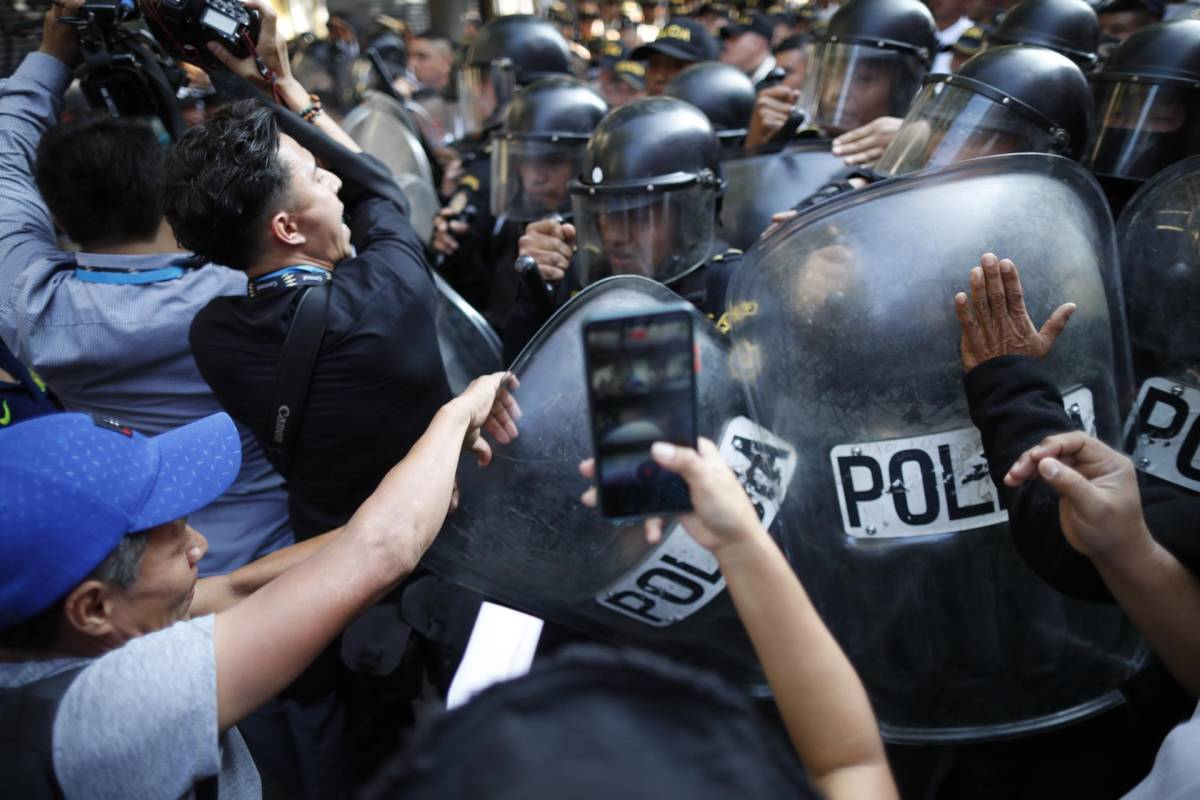 Manifestantes chocan con policías en las afueras del Congreso hoy, en Ciudad de Guatemala (Guatemala)