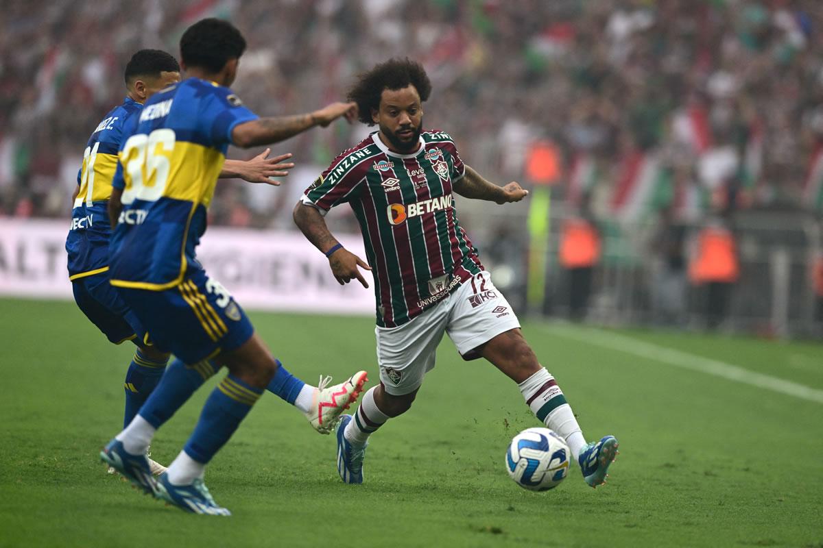 El brasileño Marcelo maneja el balón ante la marca de los jugadores Ezequiel Fernández y Cristian Medina en la final de la Copa Libertadores.