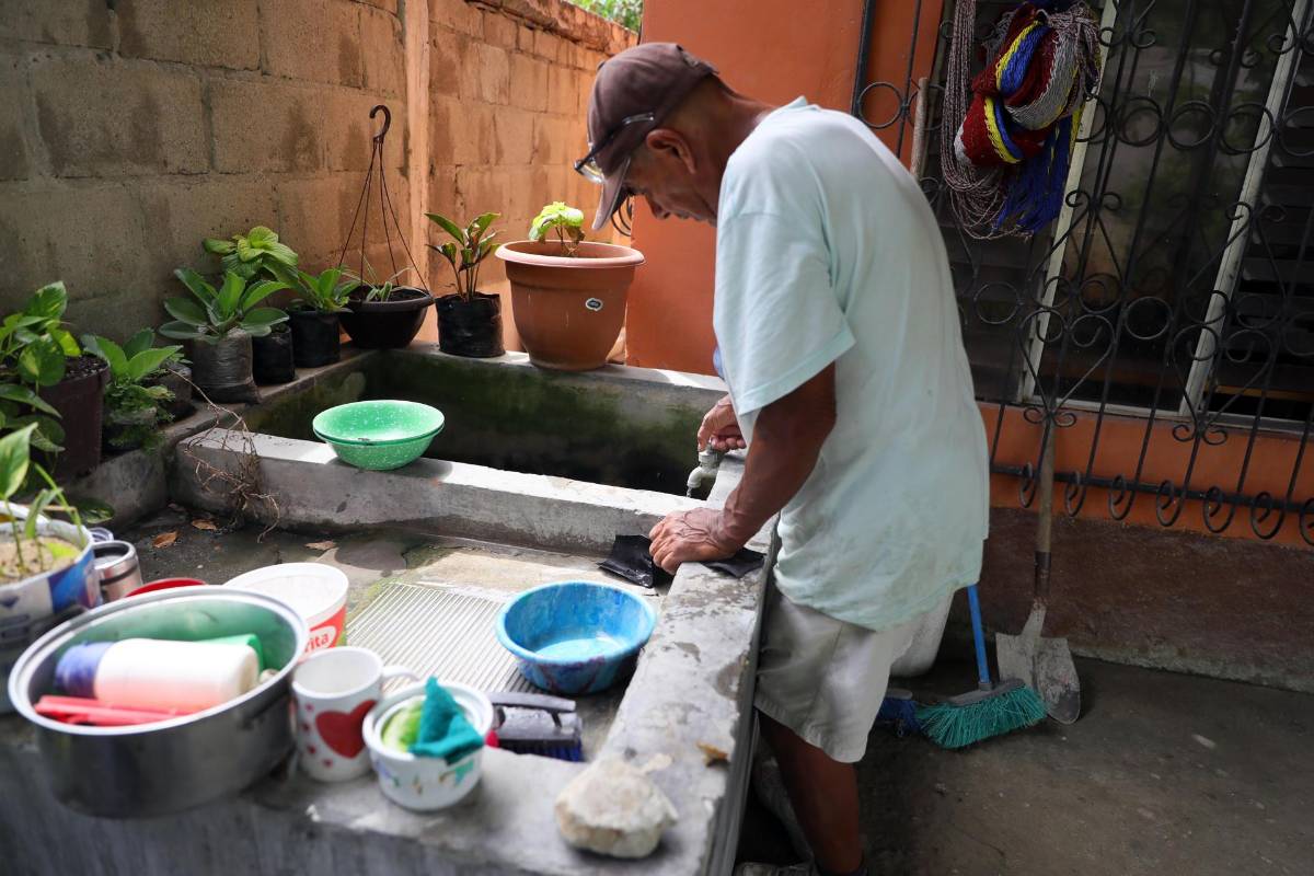 Un hombre abre una válvula para recibir agua en un barrio del municipio de Choloma, beneficiado con proyectos comunitarios para el acceso a agua potable, al norte de Honduras.