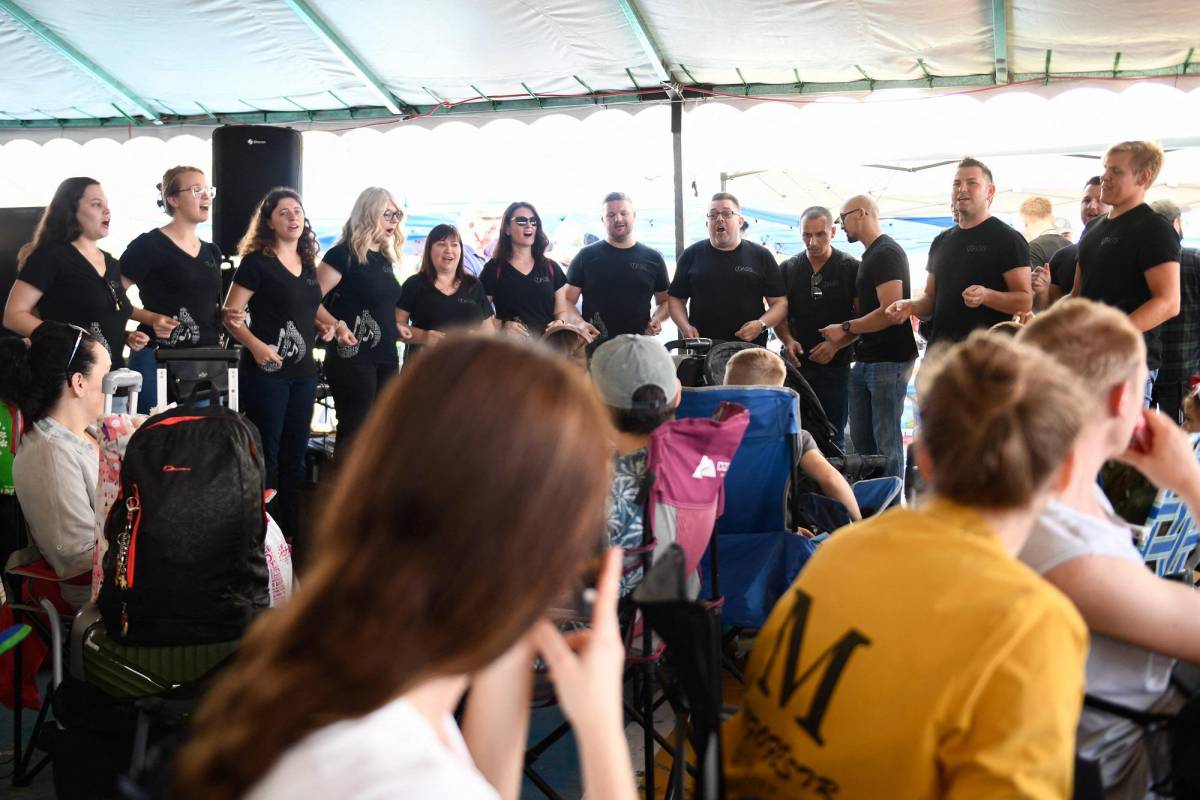 Los refugiados ucranianos son recibidos por un coro de voluntarios estadounidenses en Tijuana.