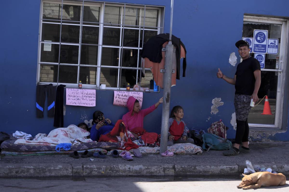 Una familia de personas migrantes de Venezuela duermen en la calle mientras piden ayuda para regresar a su país de origen hoy, en Tegucigalpa (Honduras).
