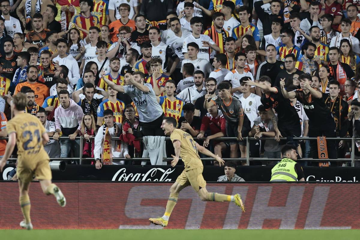 Robert Lewandowski festejando su gol mientras en el fondo la afición del Valencia luce indignada por la anotación.