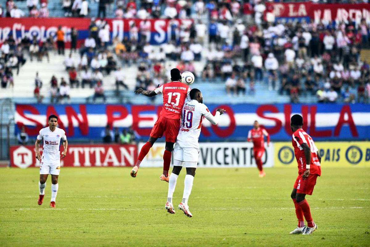 Yustin Arboleda y Luis Ortiz saltando por el balón.