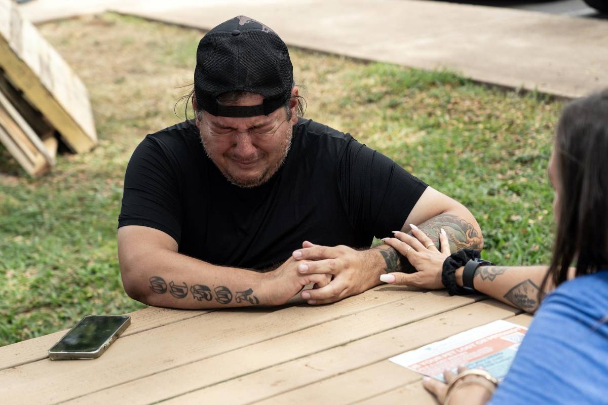 Rafael Ochoa, quien perdió su casa y sus posesiones en el incendio forestal, llora tras entregar a su perra, Bella, a la Humane Society local para que la adopten.