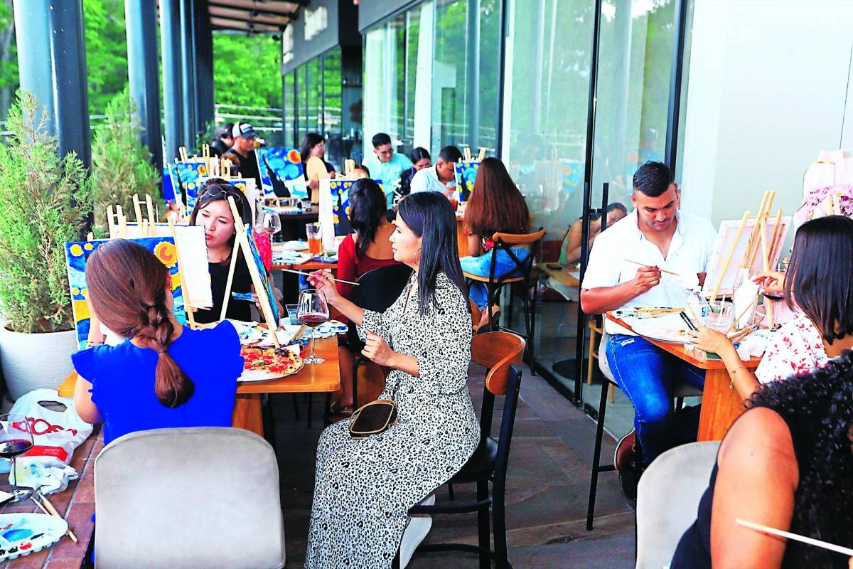 Hondureños degustan vino y pizza mientras pintan la noche estrellada de Van Gogh en una tarde de pintura de Vino Tinta.