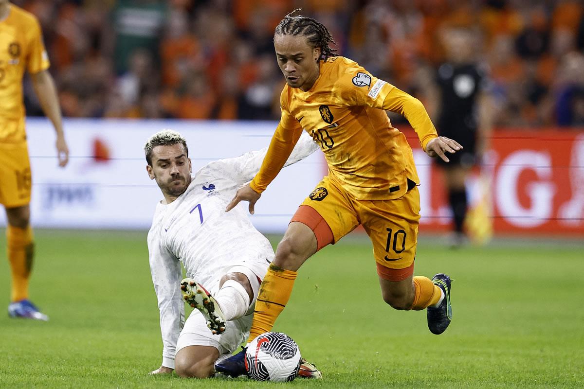 Antoine Griezmann se barre para intentar robarle el balón a Xavi Simons.