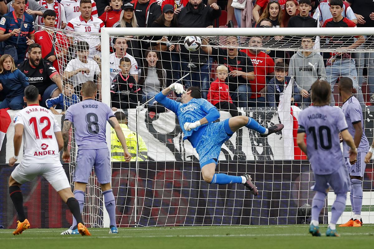 El delantero del Sevilla, Rafa Mir (i), marca ante el portero belga del Real Madrid, Thibaut Courtois, el 1-0.