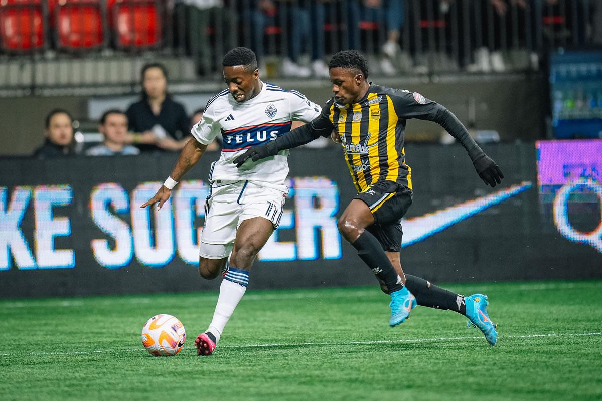 Franklin Flores marcando al delantero colombiano Cristian Dájome del Vancouver Whitecaps.