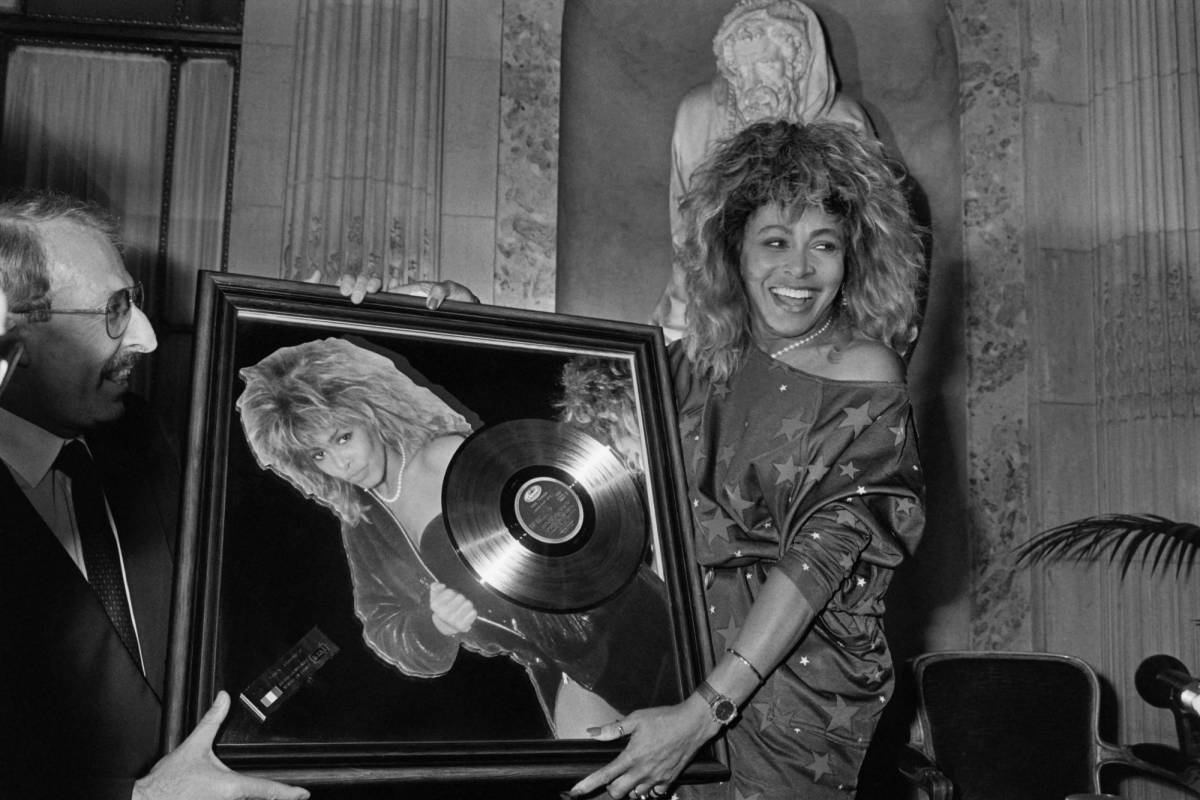 La cantante estadounidense Tina Turner recibe el premio Disco de Oro de manos del presidente de Pathé Marconi, Guy Deluz (izquierda), el 8 de octubre de 1986, en París.