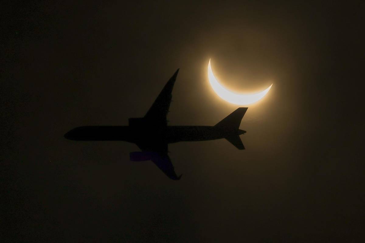 Un avión vuela durante el eclipse solar visto desde Nueva Jersey.
