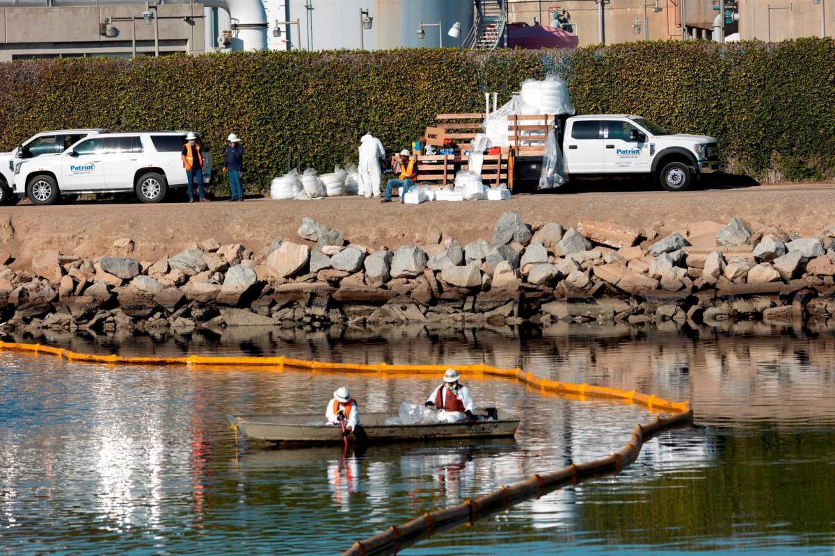 Las cuadrillas trabajan para prevenir una mayor contaminación después de un derrame de petróleo frente a la costa de Huntington Beach.