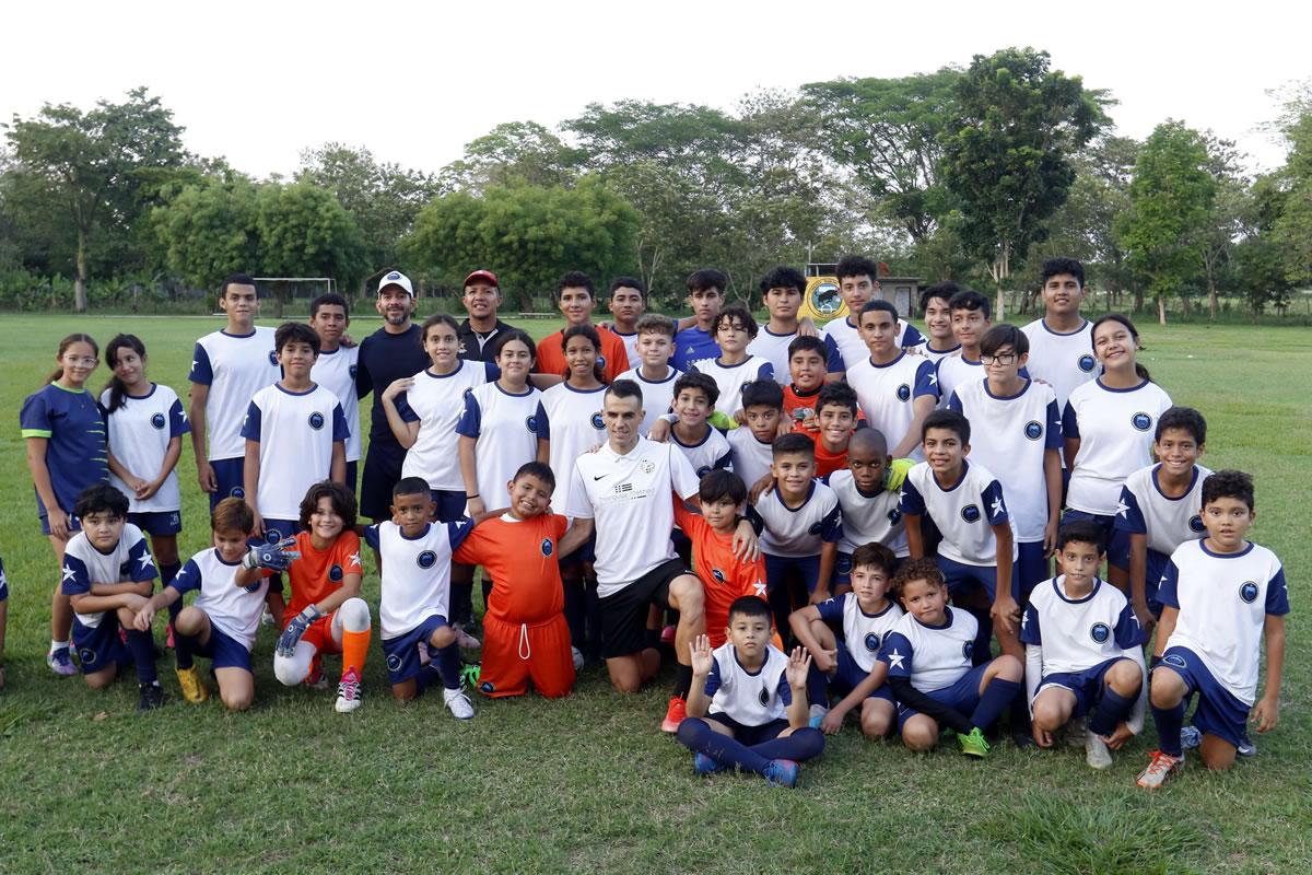 Calico posando con los jóvenes hondureños que quieren ser futbolistas.