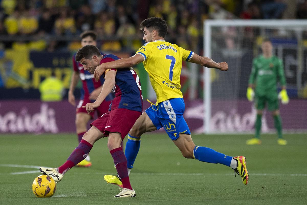 Sergi Roberto lanzando un pase, mientras es marcado por Rubén Sobrino del Cádiz.