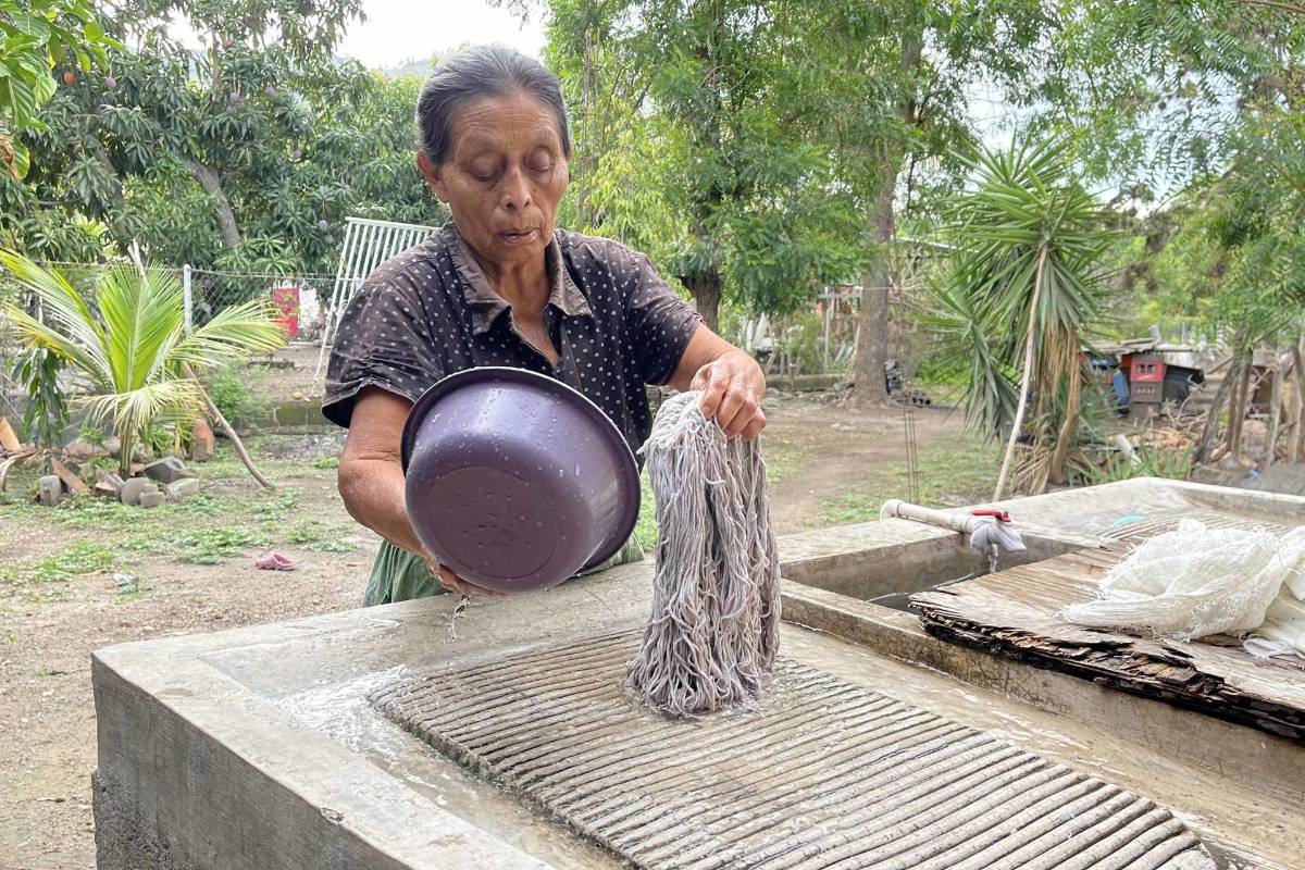 La campesina Teodolinda, lava un trapeador con agua potabilizada en una comunidad del valle de Comayagua (Honduras).