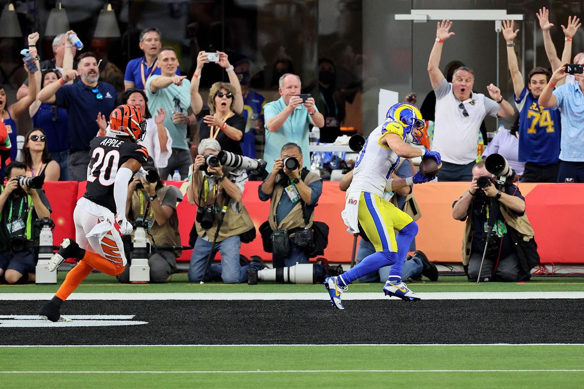 Cooper Kupp realizando la anotación y en el fondo celebran los aficionados.