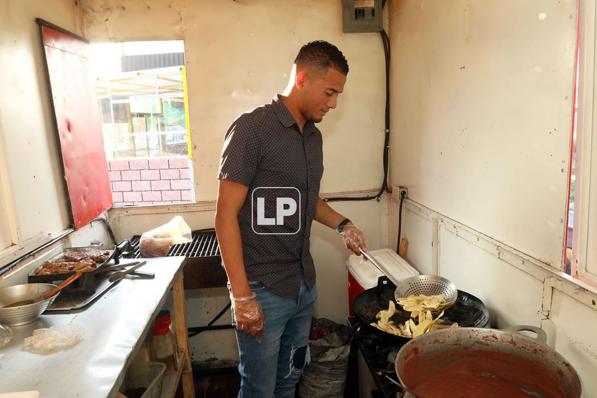 Walter Martínez mientras cocinaba unas tajadas fritas en su negocio.