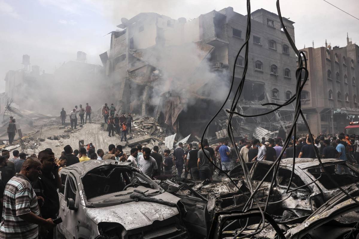 Palestinos buscan supervivientes después de un ataque aéreo israelí contra edificios en el campo de refugiados de Jabalia, en la Franja de Gaza, el 9 de octubre de 2023.