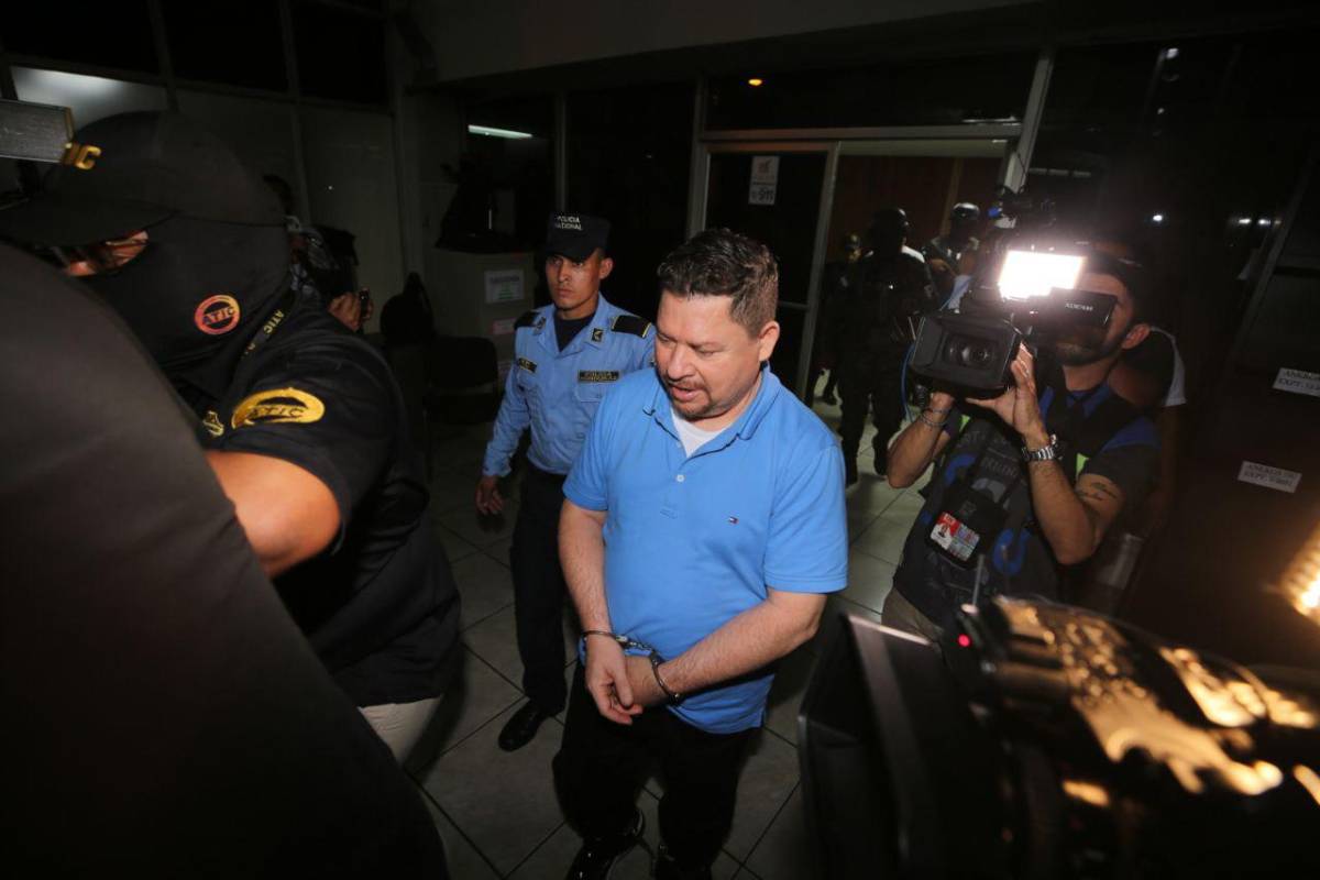 Uno de los acusados por la compra de los hospitales móviles es resguarado por policías.