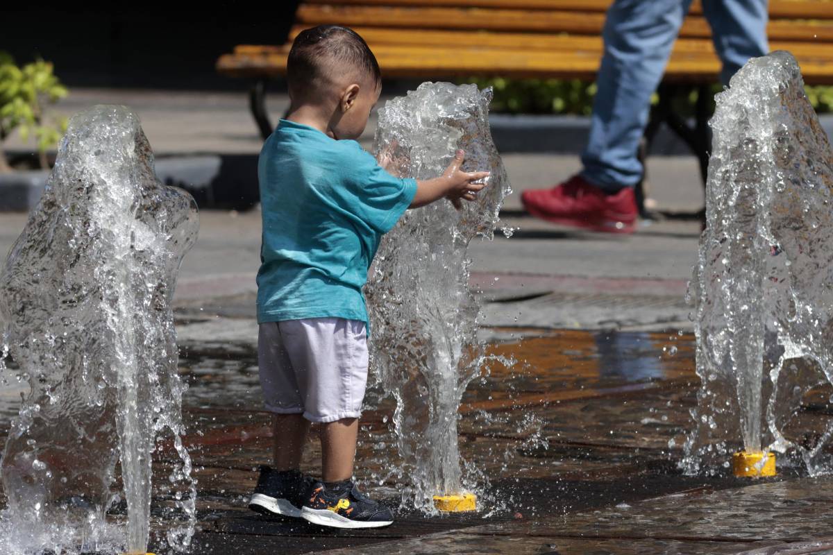 Niños se refrescan en una fuente de agua en Guadalajara, México.