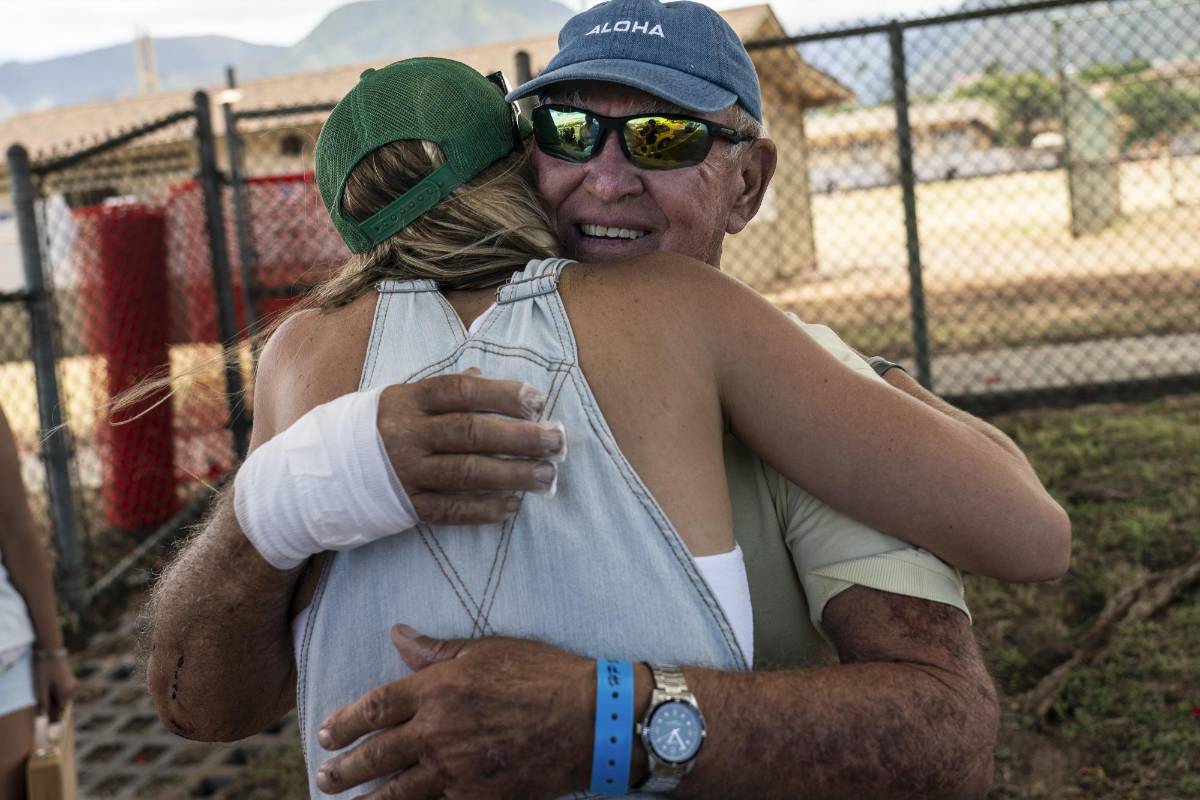 Frederick Shaw abrazando a Clair Kent, una residente de Lahaina que también sobrevivió al incendio forestal y rescató al gato de ShawÕs, Munchkin, de los escombros al día siguiente, en Wailuku, Hawái, el martes 15 de agosto de 2023.